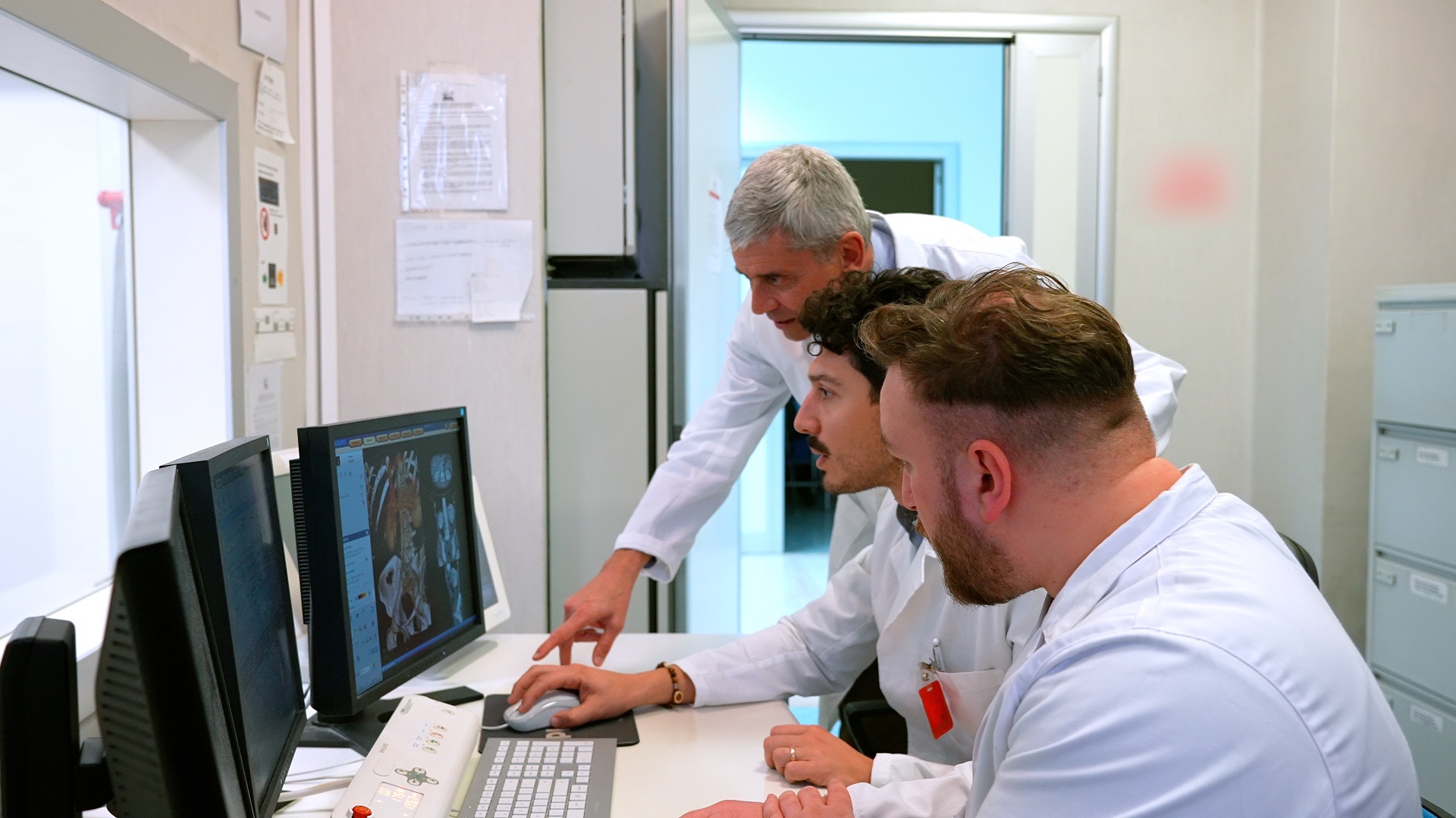 Foto di un medico che imposta una scansione sul gantry dello scanner TC, con il paziente sul lettino del sistema TC
