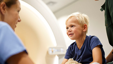 un bambino che guarda una macchina per la risonanza magnetica