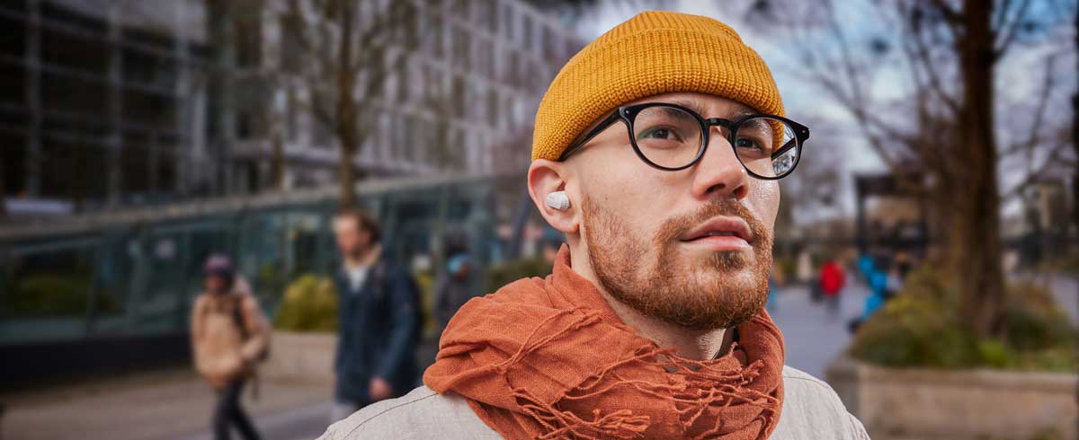 Foto ravvicinata di un uomo che indossa cuffie true wireless