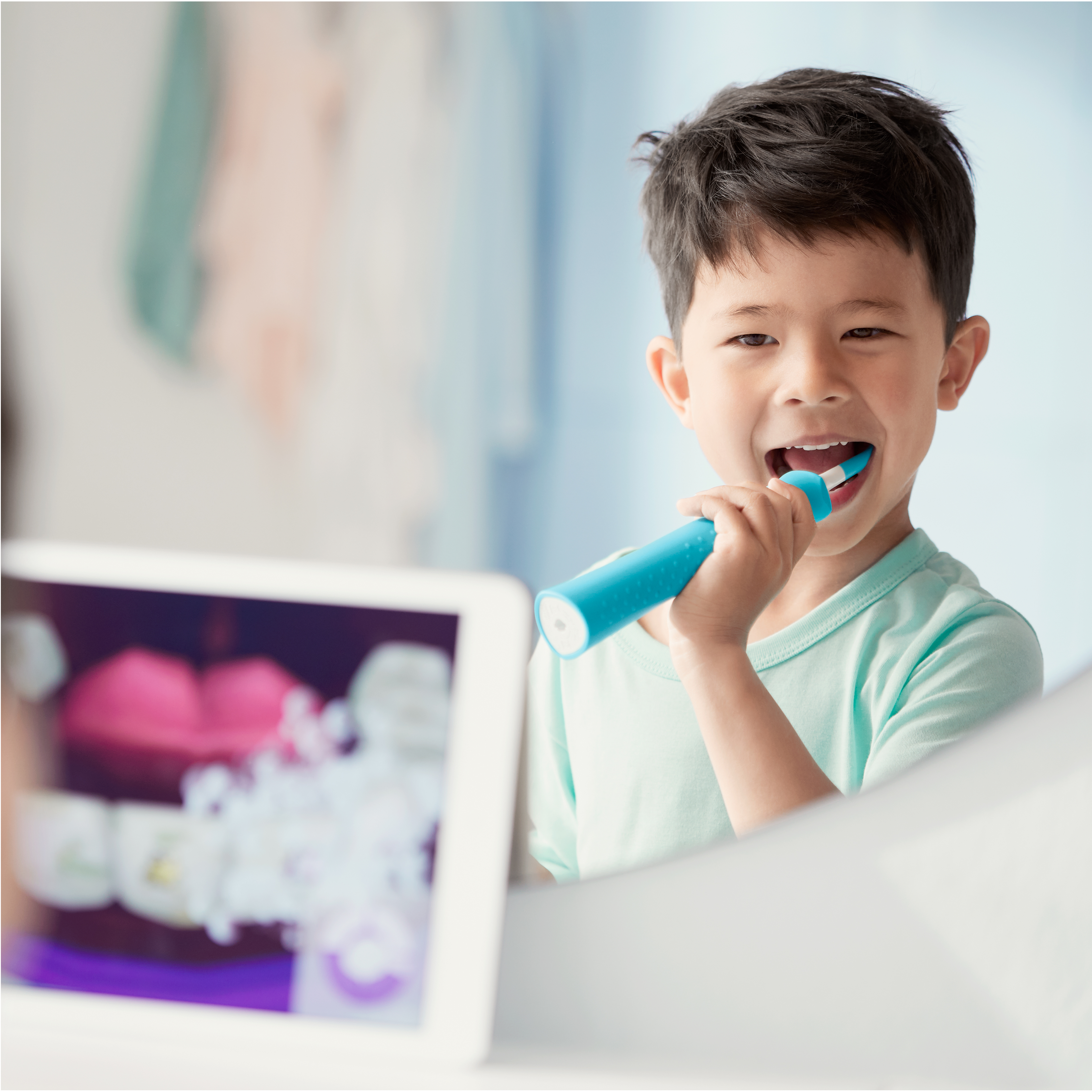 Un bambino utilizza uno spazzolino Sonicare For Kids guardando l'app Sonicare For Kids