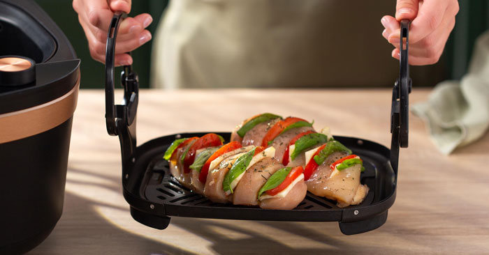 Mettere i petti di pollo sul vassoio inferiore.